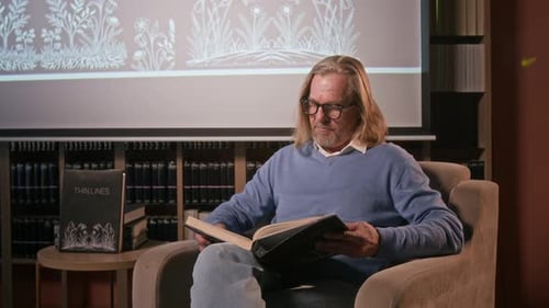 Man Reading Book in Library Easy Chair