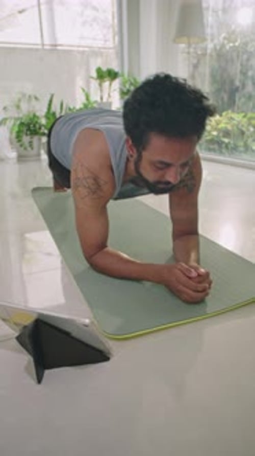 Young Adult Does Plank Exercise on Yoga Mat