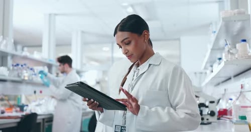 Focused Scientist Using Tablet in Modern Lab