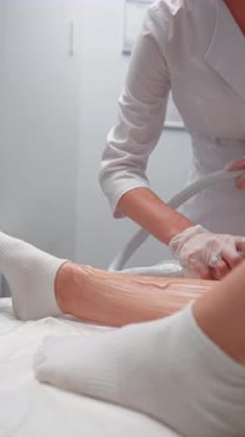 Woman Beautician Doing Legs Laser Hair Removal Procedure Female Client