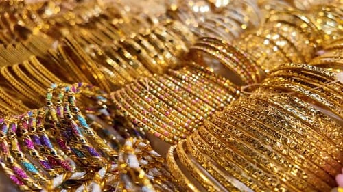 Wunderschöne Sammlung goldener Armreifen am Marktstand am Nachmittag