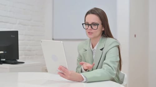 Professional Woman on Tablet Video Call in Office