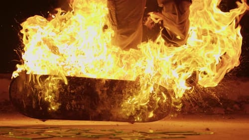 Burning Skateboard on Ground at Night
