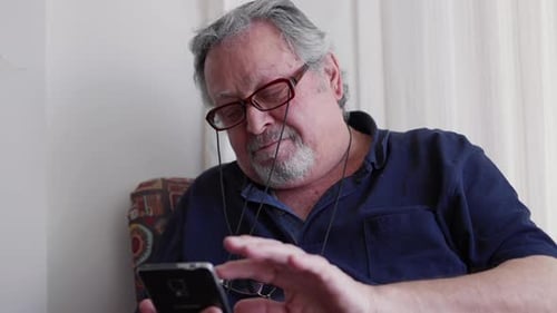 Senior Man Using Smartphone in Home