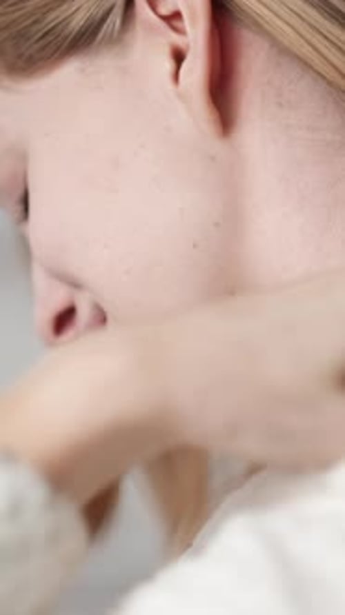 Blond Woman Massaging Her Neck Inside Home