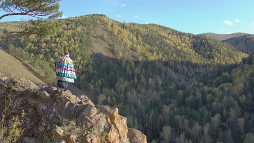 Shaman Playing a Tambourine on a Cliff in Autumn