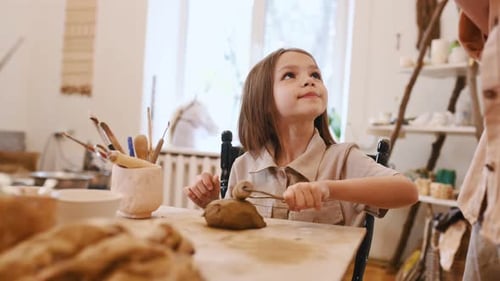 Girl Creates Clay Figure in Home Art Studio