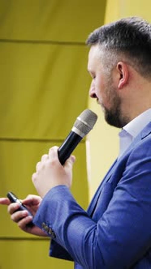 Man Giving Speech at Conference with Microphone