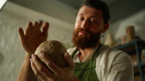A potter works clay on a potter's wheel A potter forms a clay product using pottery tools