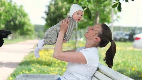 Loving Young Mom Kisses Little Infant Child Mother And Baby Kissing Happy Cheerful Family in Summer
