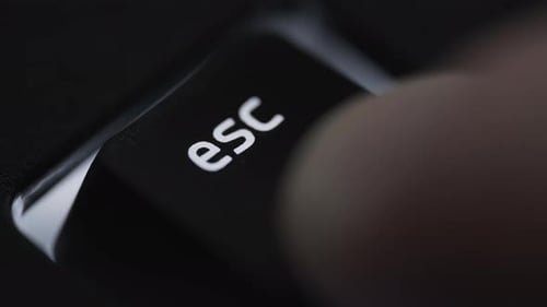 Pressing and holding escape key on black computer keyboard