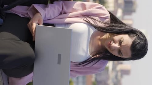 Woman Working on Laptop in City Park