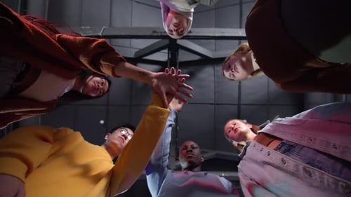 A View From Below of Young Motley People Holding Hands Demonstrating Unity Team