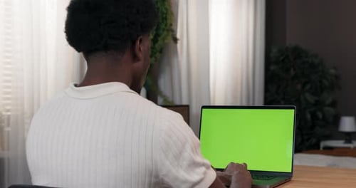 Ein Mann sitzt in einem Zimmer an einem Schreibtisch und kauft online Er sucht Online-Bekleidungsgeschäfte Der Mann