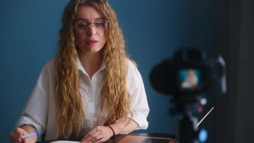Woman Vlogging with Camera and Notebook Indoors