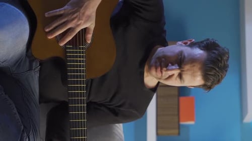 Adult Playing Guitar in an Indoor Setting