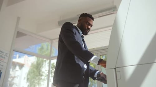 Seitenansicht eines verärgerten Bankkunden, der die Knöpfe an einem ausgefallenen Geldautomaten drückt und sich beeilt