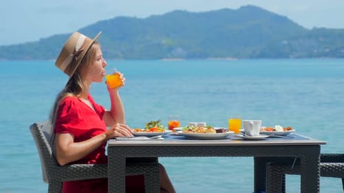 Woman on Holiday Vacation Relishes a Healthy Breakfast in a Luxury Hotel Restaurant