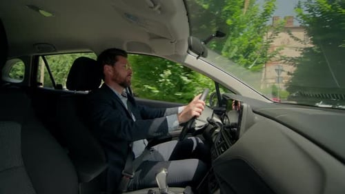 Man Driving Car Through City Streets Daytime