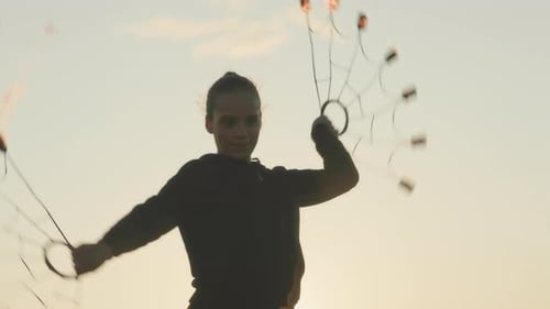 Silhouetted Woman Fire Spinning at Sunset