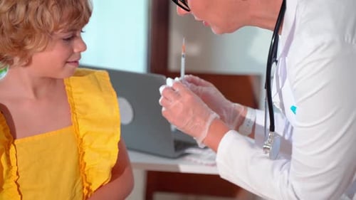 Child Vaccination in Pediatrician Hospital Medical Clinic Office Doctor Injection with Syringe