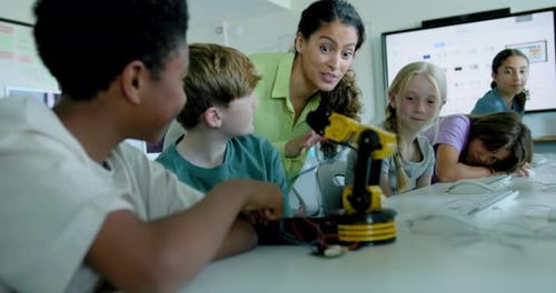 School Children in STEM Computer Classroom, Looking at Robot arm with Teacher