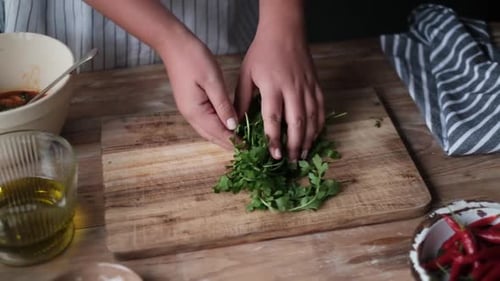Chopping Fresh Parsley on Wooden Cutting Board