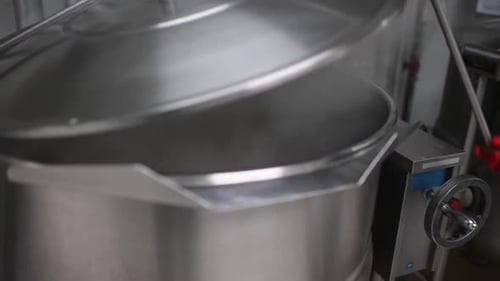 Cooking food or soup with huge pot in food factory or kitchen.