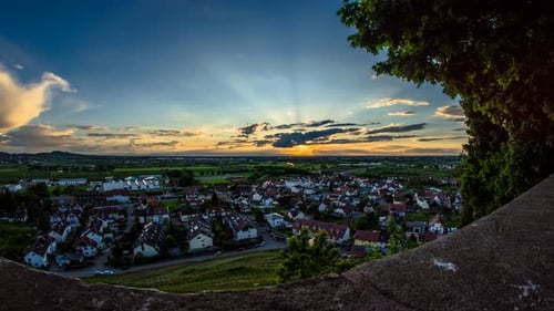 time lapse sunset over city with clouds and sunbeams