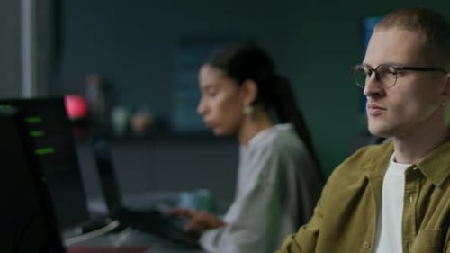 Junges multiethnisches Programmiererteam, das nachts im Büro arbeitet