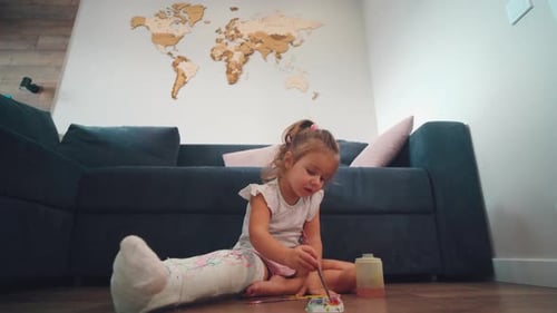 Little Girl With Cast Painting at Home
