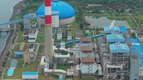 Blick aus der Vogelperspektive auf ein Kohlekraftwerk an der Küste von Bali, Indonesien. Das industrielle