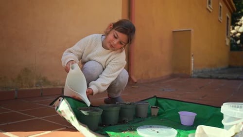 Young Girl Watering Plants on a Sunny Patio