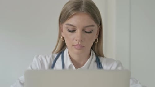Close Up of Female Doctor Working on Laptop in Clinic