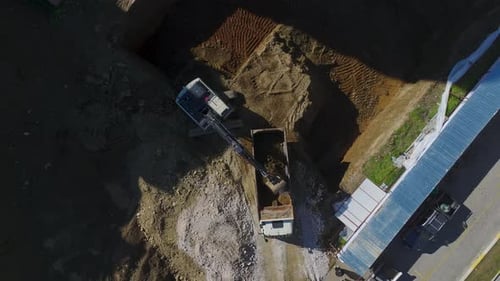Aerial View of Excavator Loading Dump Truck at Construction Site