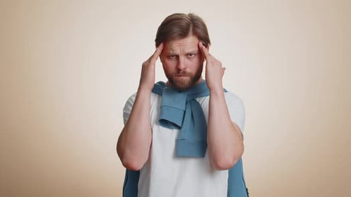 Man Holding Temples in Apparent Headache Pain