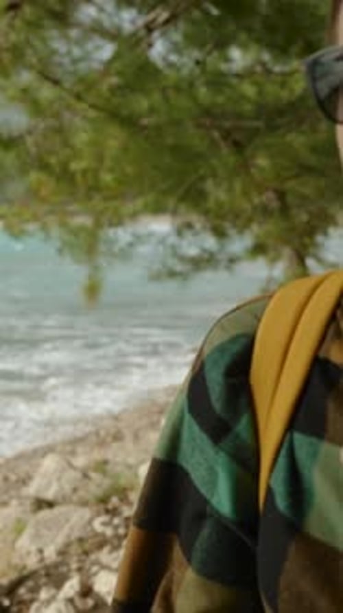 Woman Walking Along Ocean Shoreline on Overcast Day