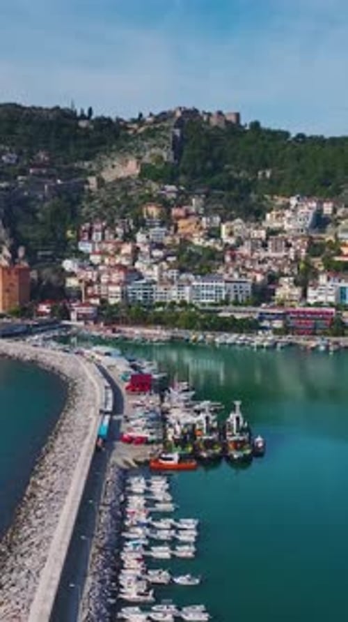 Vertical Video of a Fishing Port With Wooden Boats and Luxury Yachts Captured From a Drone With a