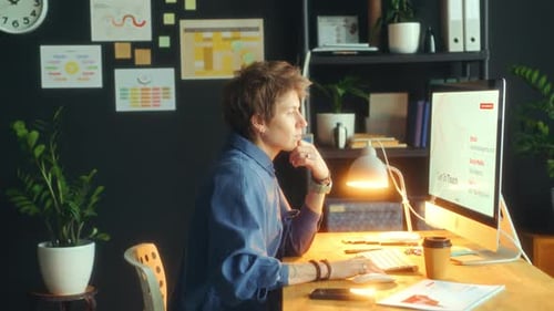 Businesswoman Analyzing Chart and Working on Computer in Office