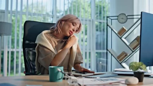 Businesswoman Talking on Phone at Office Desk
