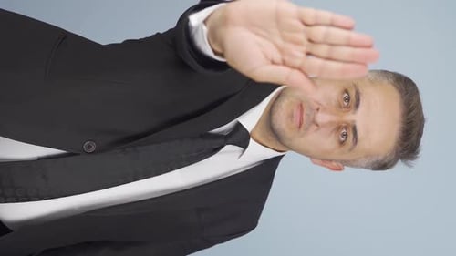 Man in Suit Puts Hand Up to Camera