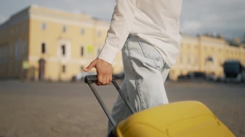 Woman Rolling Big Yellow Suitcase Walking on Square in Downtown Closeup View Tourism and Travelling