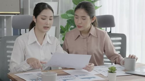 Deux jeunes femmes d'affaires enthousiastes travaillant ensemble dans l'espace de travail