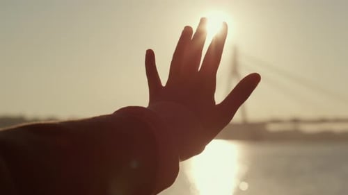 Girl Hand Silhouette in Golden Sunlight Closeup. Dreamy Romantic Mood Concept. Unrecognized
