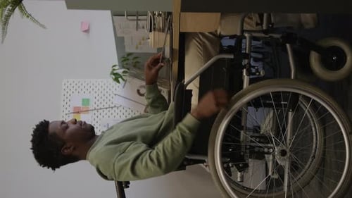 African American Man with Disability Working on Laptop in Office