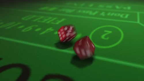 Pair of dice thrown onto a craps or crapaud table with glittering poker machines in a casino backgro