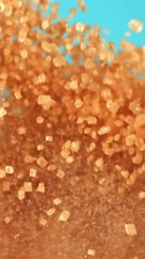 Cane Sugar Soars Against a Blue Background Filmed on a Highspeed Camera at 1000 Fps