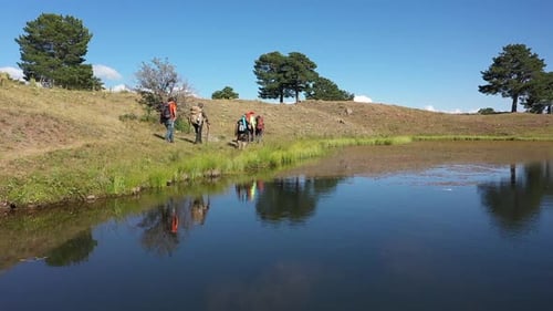 Group Of People Trekking By The Lake