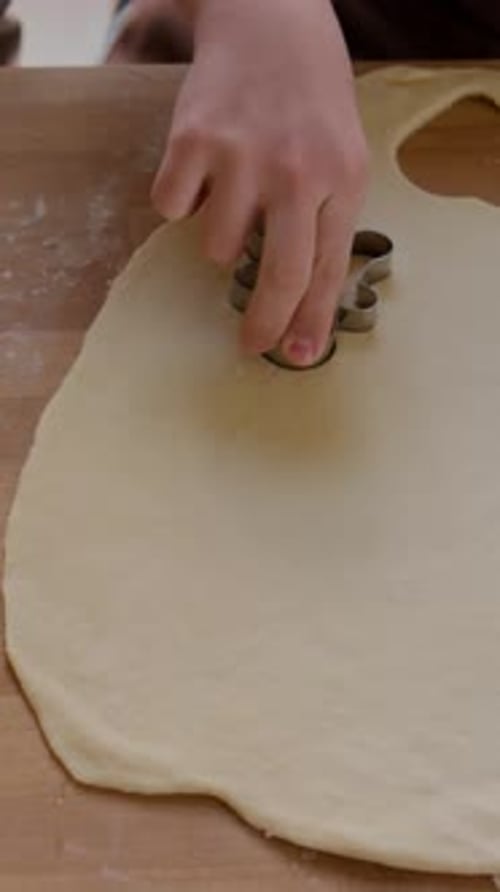 Close-Up of Female Hands Cutting Gingerbread Man Out of Cookie Dough