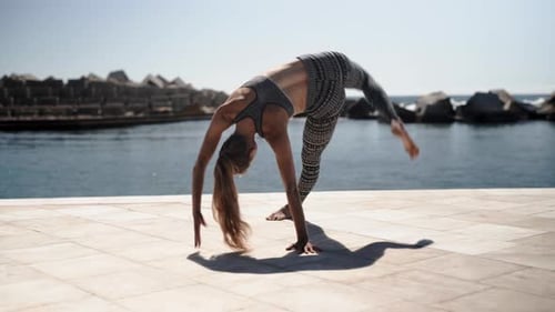 Estiramientos de yoga con flexiones en el puerto de Barcelona, España